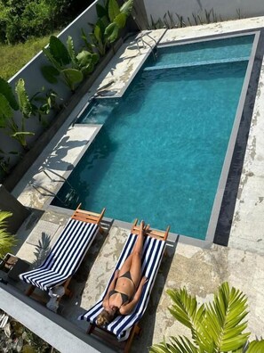 Piscina a l'aire lliure, para-sols i gandules