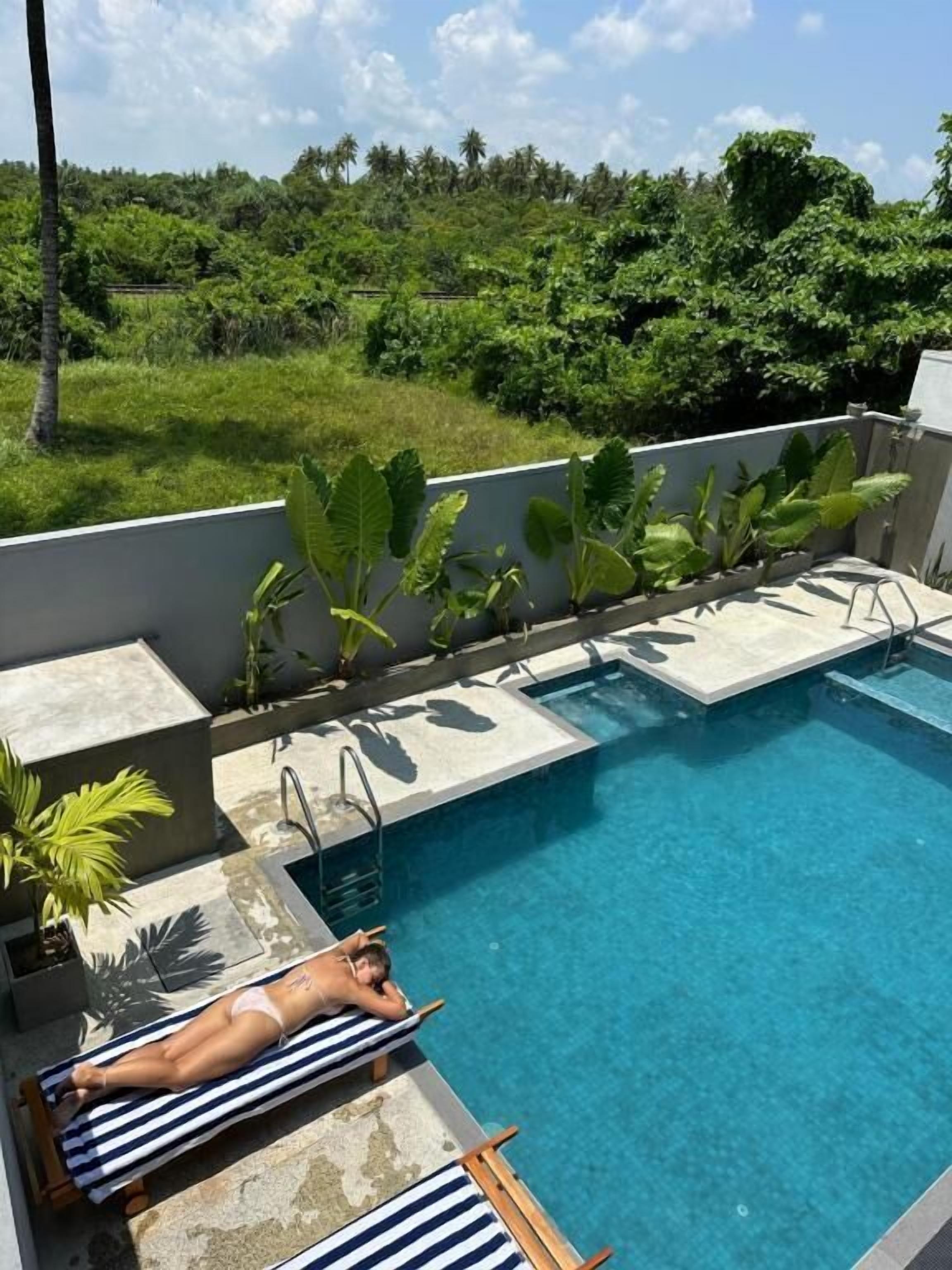 Een buitenzwembad, parasols bij het zwembad en ligstoelen