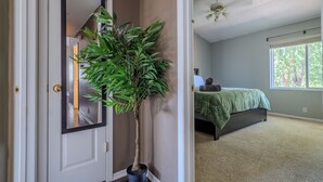 Une chambre à coucher avec un lit, une fenêtre et une plante en pot.