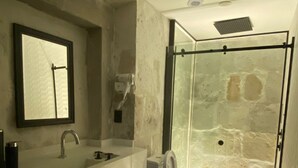 Une salle de bain avec un grand miroir, un lavabo et des toilettes.