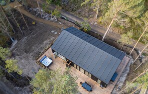 A modern cabin with a metal roof, a hot tub, and a deck with outdoor seating. - Nice home in Nexø with sauna (Nexø)
