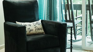 A black armchair with a cushion that reads "Like is Better than the Pines." - Three Little Pines Condo 2BD 2BA with Pool Close to Village and Pinehurst Resort (Pinehurst)