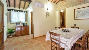 A dining area with a table covered in lace, wooden chairs, and a tiled floor. - Amazing home in Todi with swimming pool (Todi)
