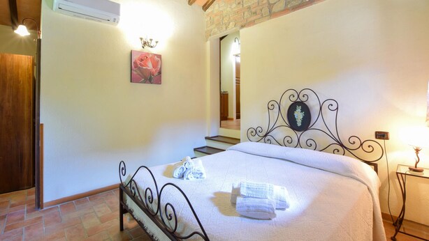 A bedroom with a bed, a chandelier, a painting, and a staircase. - Amazing home in Todi with swimming pool (Todi)