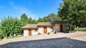 A stone building with a tiled roof, two wooden doors, and a paved driveway. - Amazing home in Todi with swimming pool (Todi)