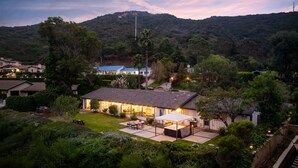 A residential property with a spacious patio, a swimming pool, and a view of a mountain.