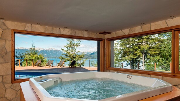 Ein Whirlpool mit Blick auf einen See und Berge.
