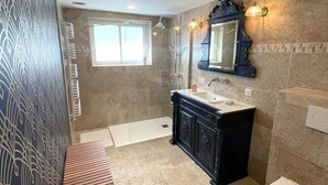 Un baño con bañera, lavamanos, inodoro y tocador con espejo.