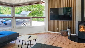 A modern living room with a TV, fireplace, and seating area. - Stunning home in Oksbøl with sauna (Oksbøl)