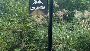 Un letrero con un icono de montaña y casa, que dice 'LOCANDA'.