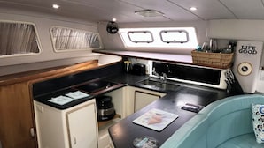A compact galley with a sink, stove, and storage cabinets.