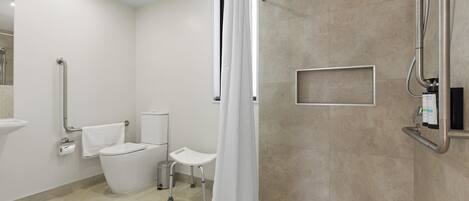 A modern bathroom with a toilet, bidet, and shower area, including grab bars and a white shower curtain.