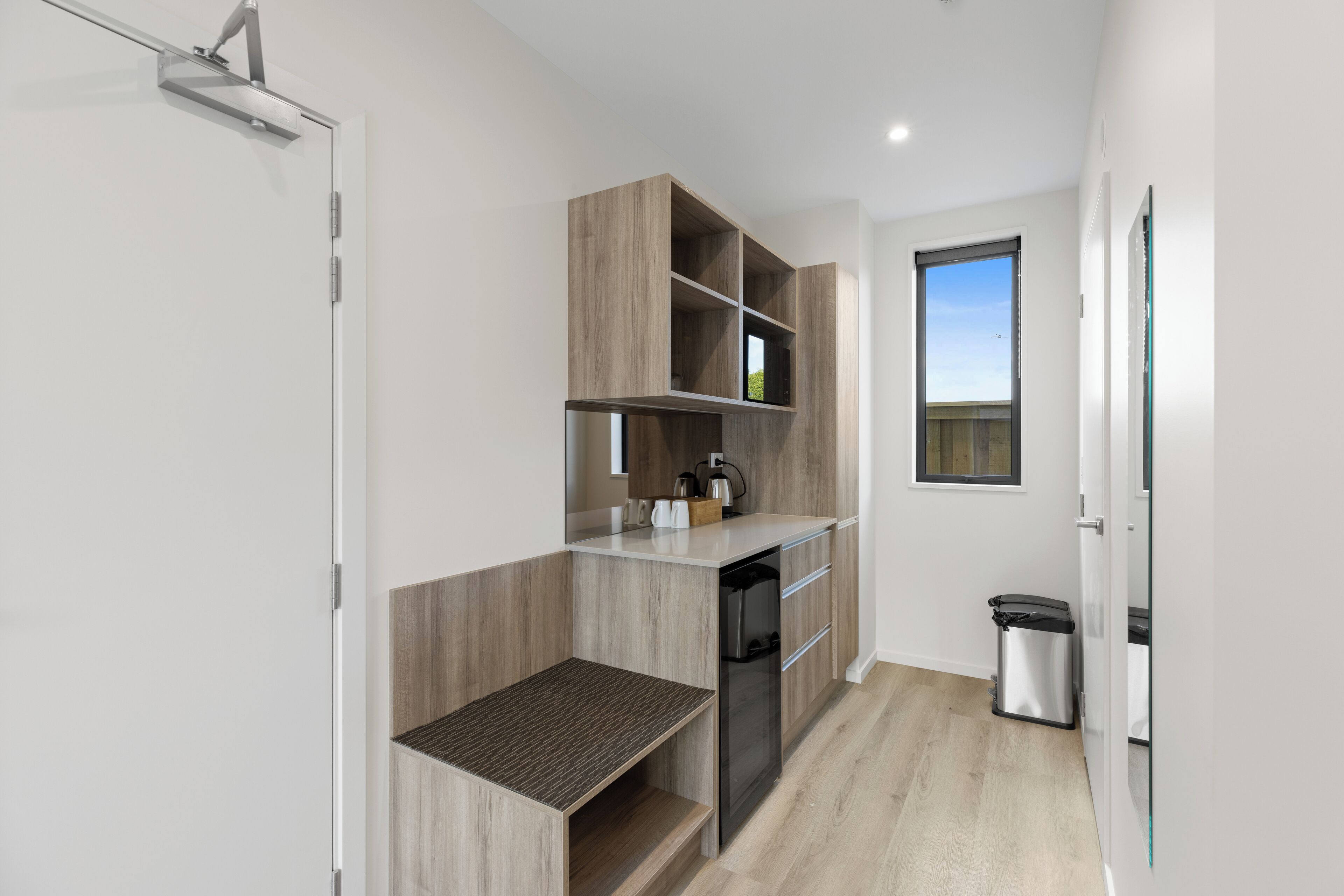 A compact kitchen with built-in appliances, a small countertop, and a window providing natural light.