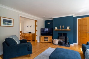 Un salon avec une télévision, des meubles en bois et une cheminée.
