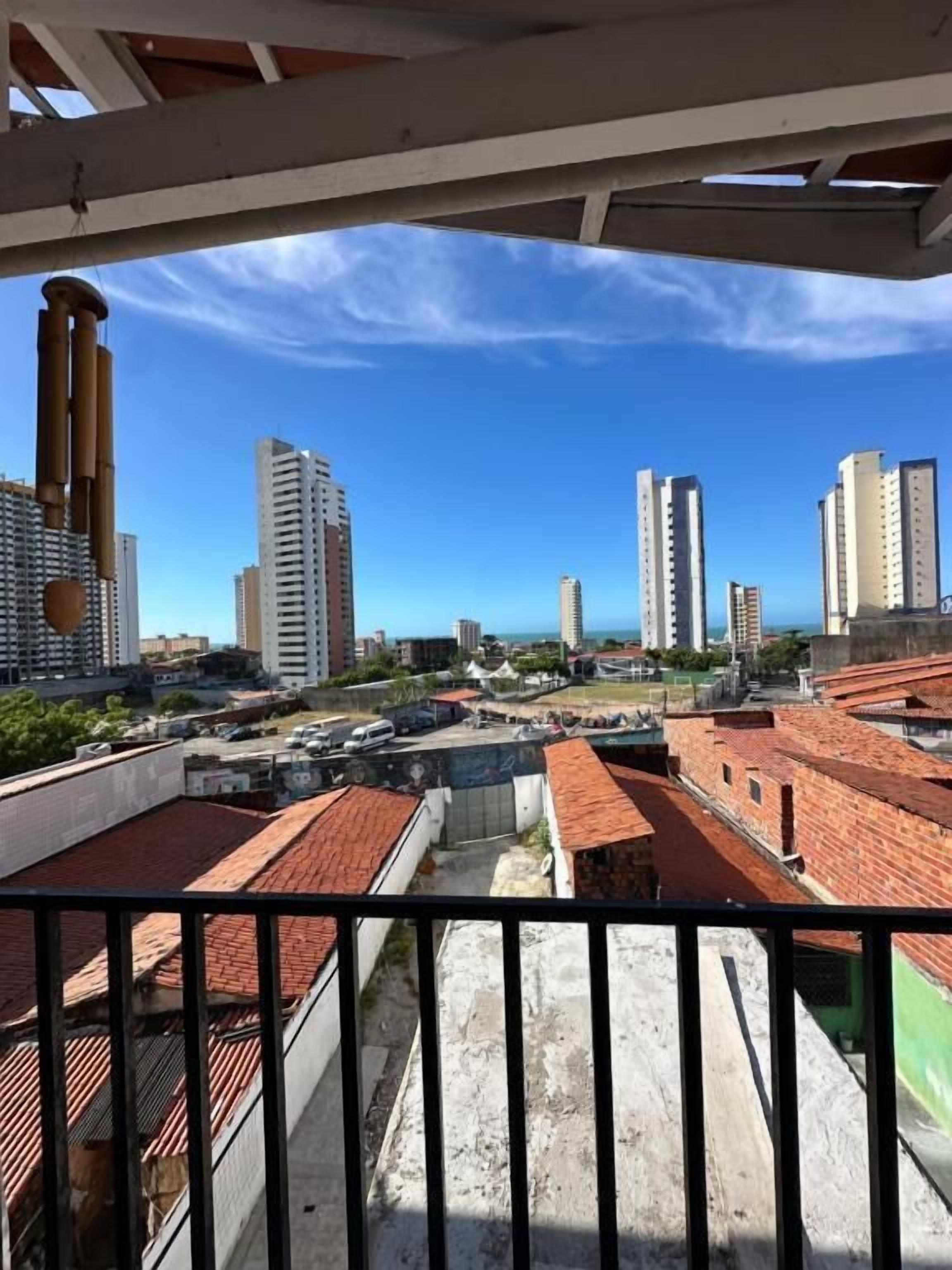 A balcony with a view of high-rise buildings and a clear sky.