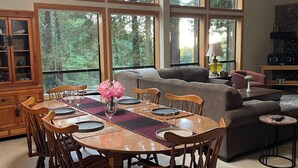A dining area with a wooden table set for six, surrounded by wooden chairs. - Beautiful Large Home w Game Room on Private Acreage  (Gualala)