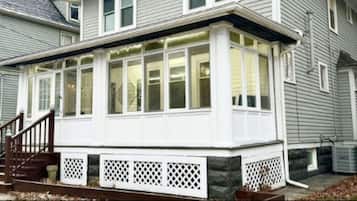 A two-story house with a covered porch and a staircase leading to the entrance.