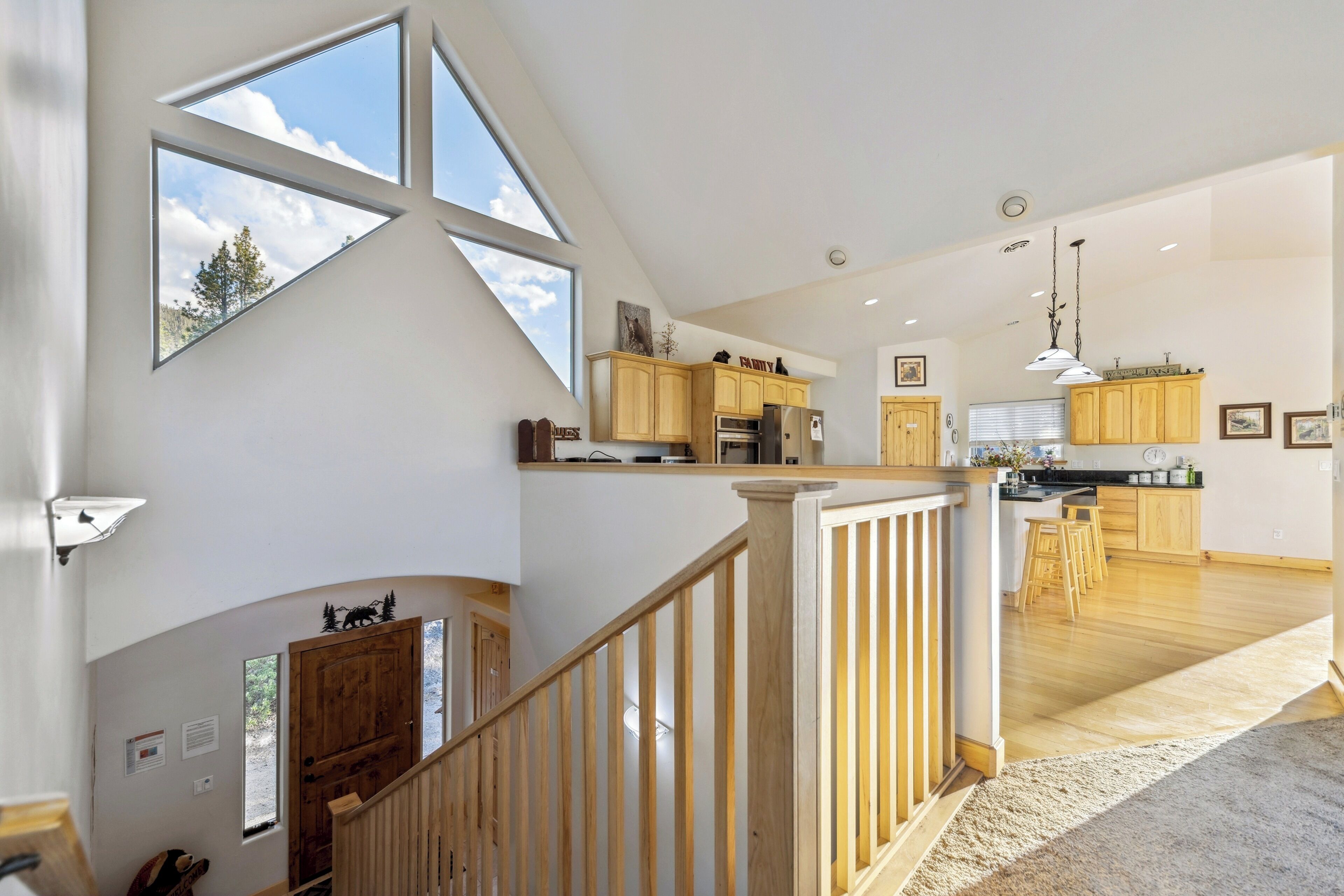 Una cocina amplia con armarios de madera, una isla central y vistas al exterior gracias a grandes ventanales.