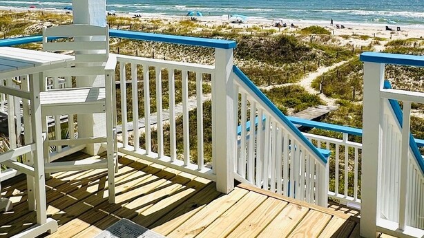 A wooden deck with white railings and a view of the beach. - Splash on St. George Island, beachfront, beautiful, close to everything (Eastpoint)