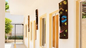 Un corridoio con porte, un cancello e un muro con un elemento decorativo.