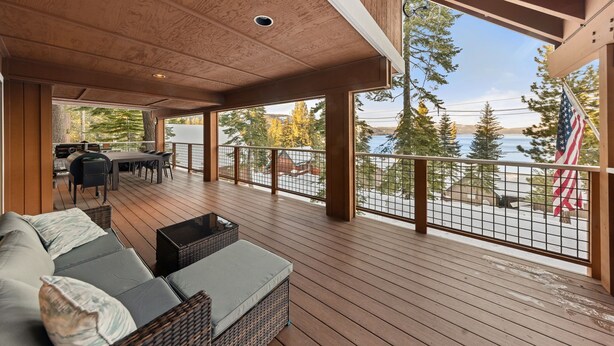 A covered deck with a sofa, a dining table, and chairs. - McKinney Lakeview Lodge in Homewood (Tahoma)