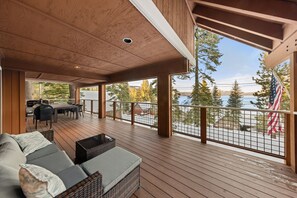 Une terrasse couverte avec un canapé, une table à manger et des chaises.