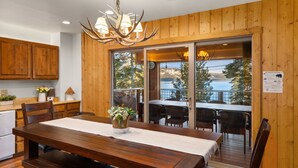 A wooden interior with a dining table, chairs, and a chandelier. - McKinney Lakeview Lodge in Homewood (Tahoma)