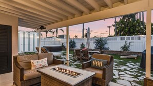 A covered patio with wicker furniture, a fire pit, and a view of the backyard. - New Modern Luxury, 3/2 Fam Friendly, BBQ, Central! (Encinitas)