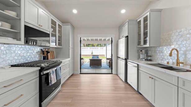 A modern kitchen with white cabinetry, a black oven, and a tiled backsplash. - New Modern Luxury, 3/2 Fam Friendly, BBQ, Central! (Encinitas)