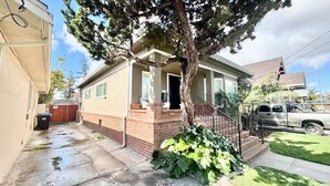 Una casa a un piano con veranda, garage e vialetto.