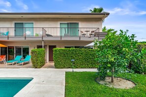 Un bâtiment à deux étages doté d’un balcon, d’une piscine et d’un jardin bien entretenu.