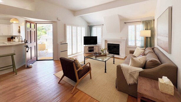 A spacious living area with a sofa, armchair, and a television. - Luxurious Seabreeze Chic, 2 Bed Condo (Newport Beach)