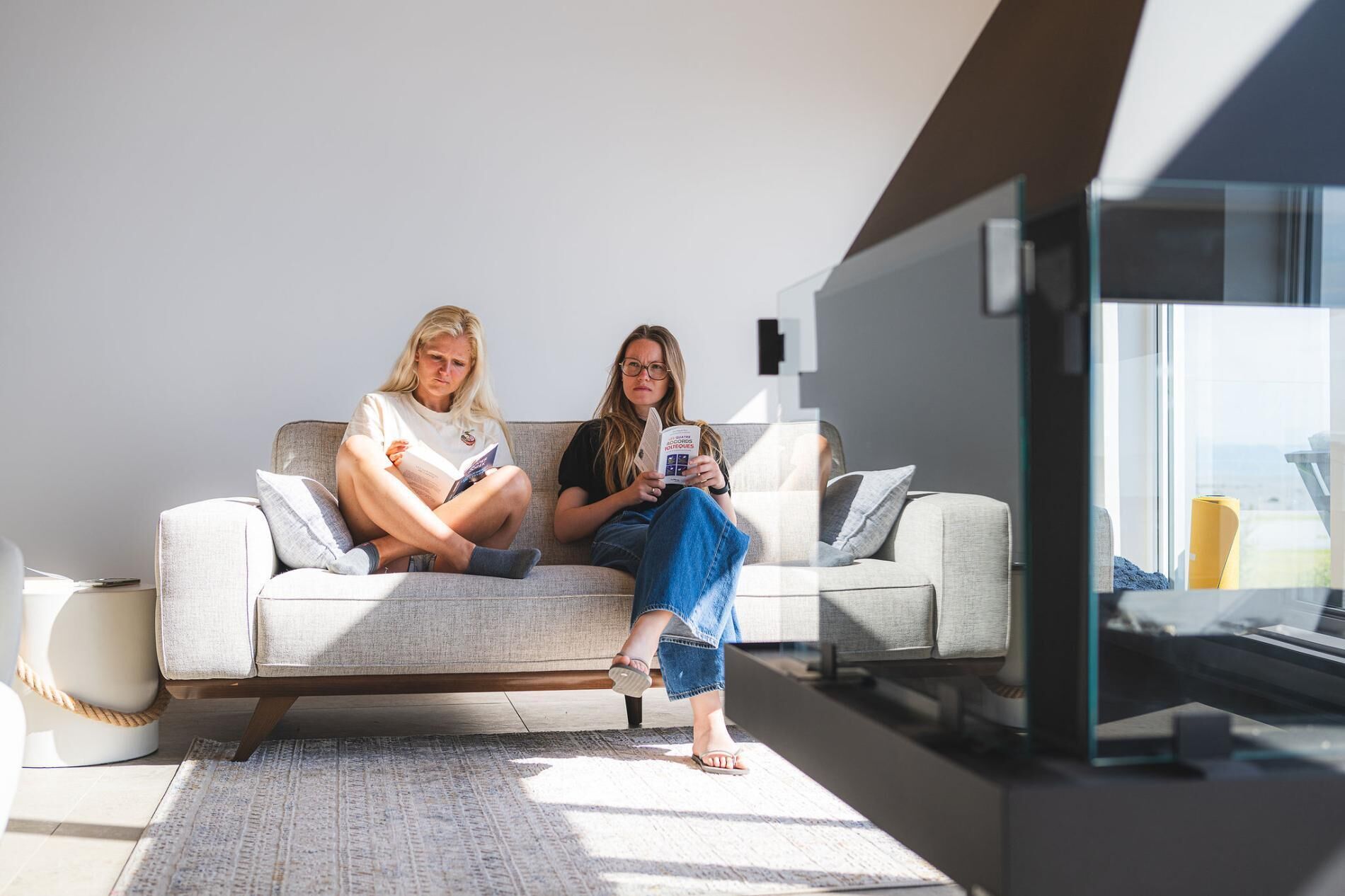 En moderne stue med sofa, sofabord og stort vindue.