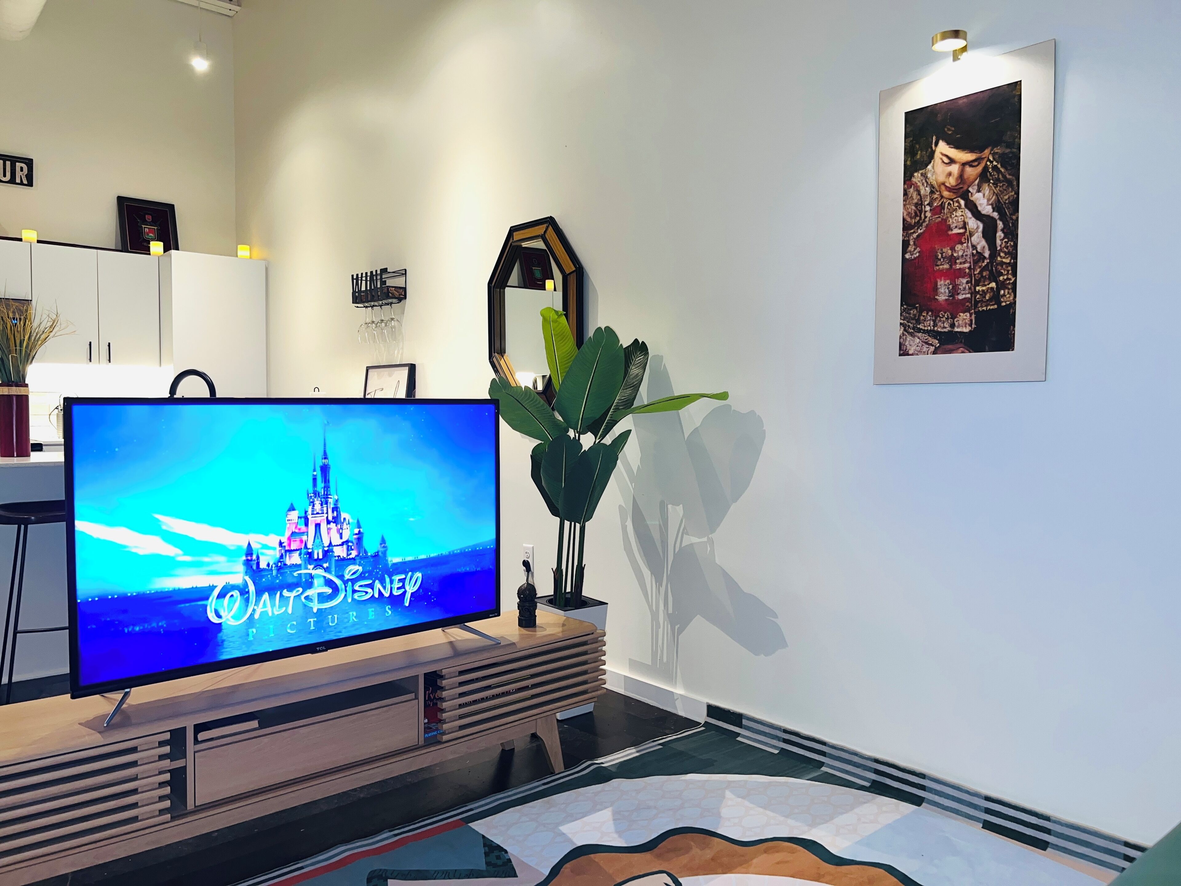 A modern living room with a flat-screen TV displaying 'Walt Disney Pictures'.