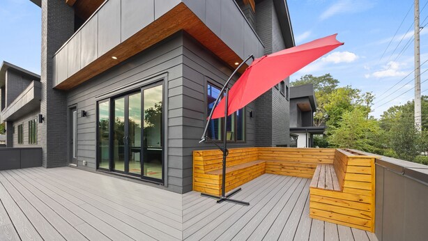 A modern outdoor deck with a wooden bench and a red umbrella. - Luxury 4BR Near BeltLine Hot Tub Game Room  Sleeps 10 (Atlanta)