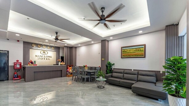 A hotel reception area with a modern design, featuring a reception desk, seating area, and a large painting on the wall.