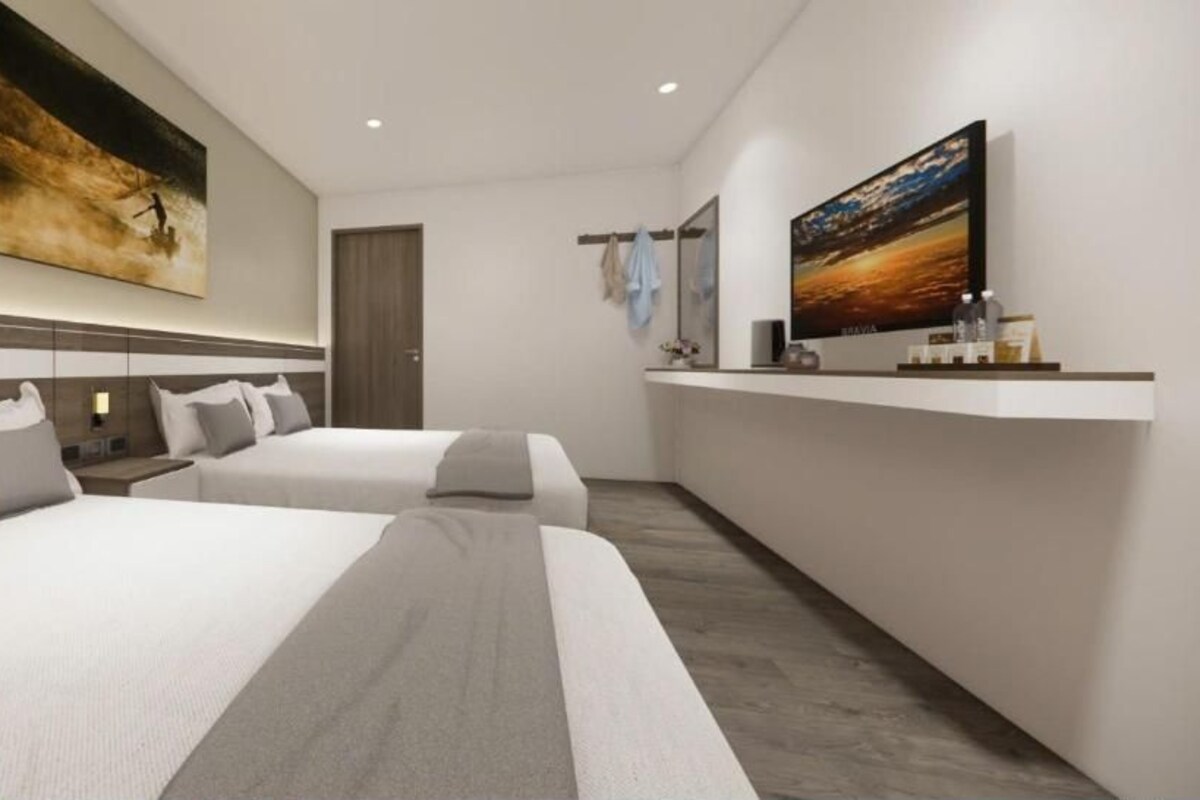 A modern hotel room with two beds, a large painting on the wall, a small desk, and a TV on a stand.