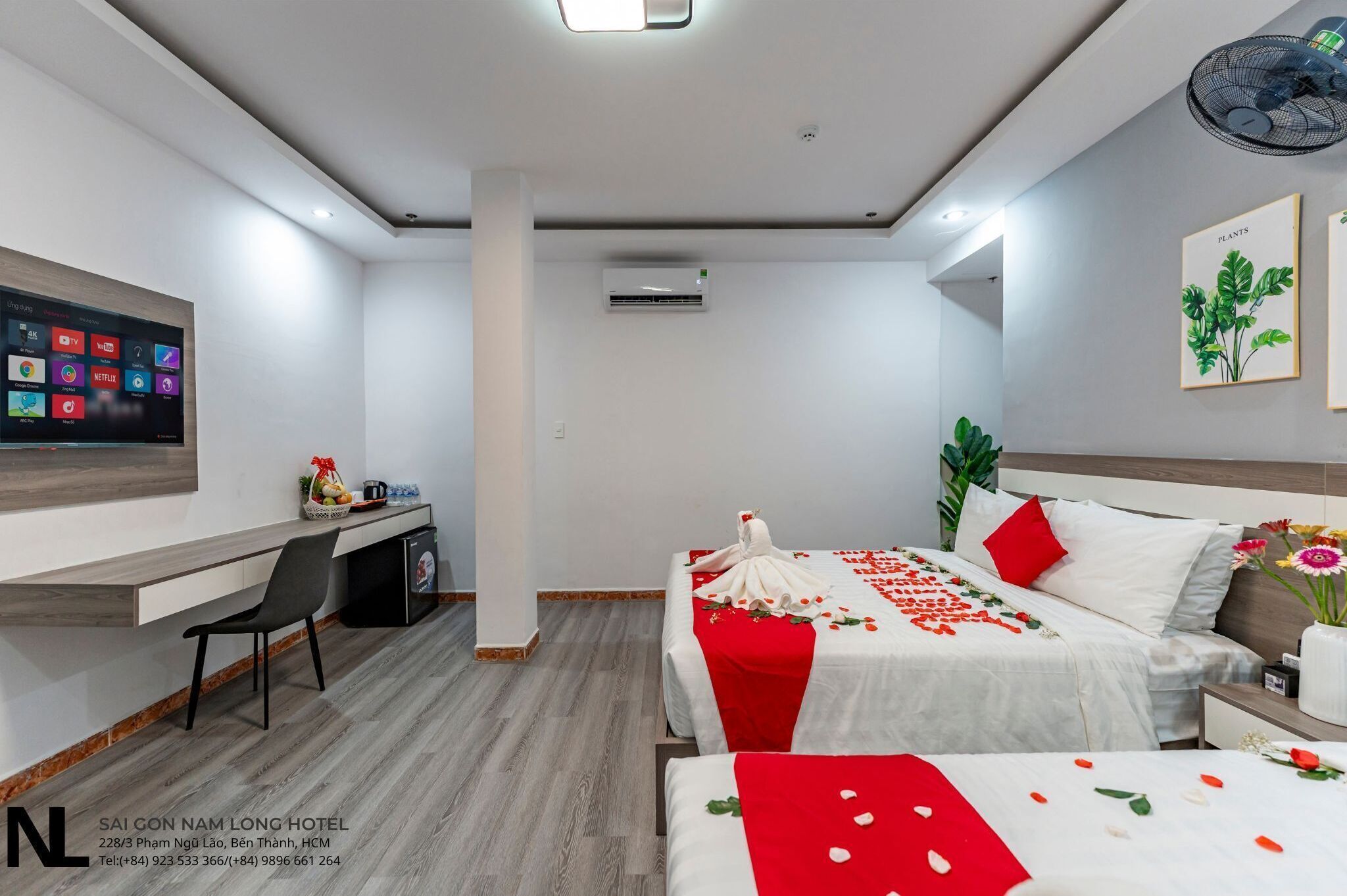 Hotelkamer met een bed, een bureau, een stoel, een televisie en een wandairconditioner.