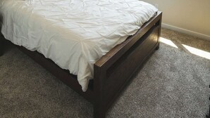 Een slaapkamer met een bed, plafondventilator, raam en lamp.