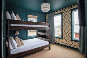 A bunk bed in a room with teal walls, patterned wallpaper, and large windows. - CMA Fest rooftop fire pit, skyline views, garage near Broadway (Nashville)