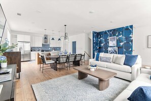 A modern living room with a sofa, coffee table, and dining area.