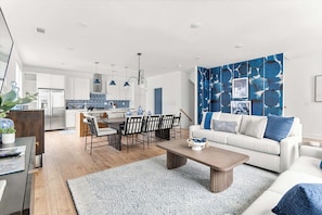 A modern living room with a sofa, coffee table, and dining area. - Rooftop fire pit house with skyline views, sleeps 10 near Broadway, Nashville (Nashville)