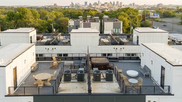 A rooftop terrace with seating, air conditioning units, and a city skyline view. - Nashville 4-bedroom house with gas grill, sleeps 12, pet friendly (Nashville)