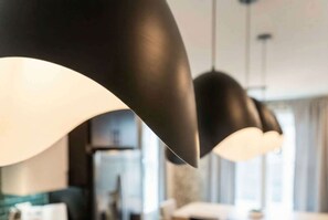 A modern kitchen with pendant lights and a refrigerator.