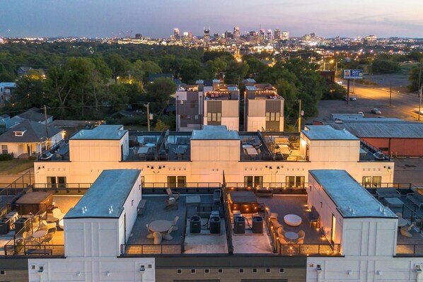 A rooftop terrace with outdoor seating and a city view.