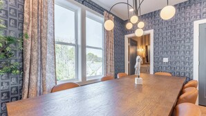 A dining area with a wooden table, leather chairs, patterned curtains, and pendant lights. - Weekend getaway: private hot tub, 4 bedrooms, sleeps 12 near Nashville (Nashville)