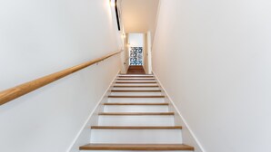 A modern staircase with wooden steps and a white handrail.