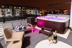 City lights twinkle beyond the hot tub as you lounge poolside on the rooftop, making this the go-to spot for group getaways in Nashville