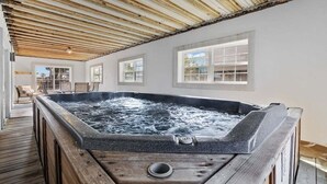 A hot tub in a wooden deck area with a wooden ceiling and windows. - Iconic 8BR w/ Rooftop Deck, Pool & Spa | Sleeps 24 (North Myrtle Beach)