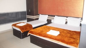 A hotel room with two beds, a wardrobe, and a large mirror. - SSR HOTEL (Srikalahasti)